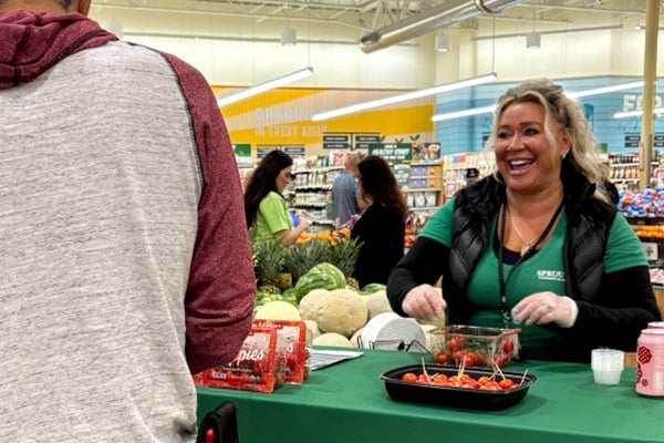 Vendor Village representative sharing samples of tomatoes with customers