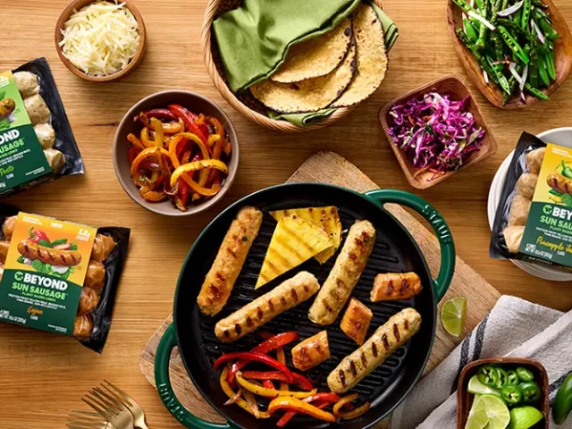 Beyond sausage varieties next to a pan of cooked sausage